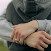 A person hugging another person both wearing hooded jumpers