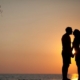 A silhouette of a couple kissing in the sunset whilst stood on the beach